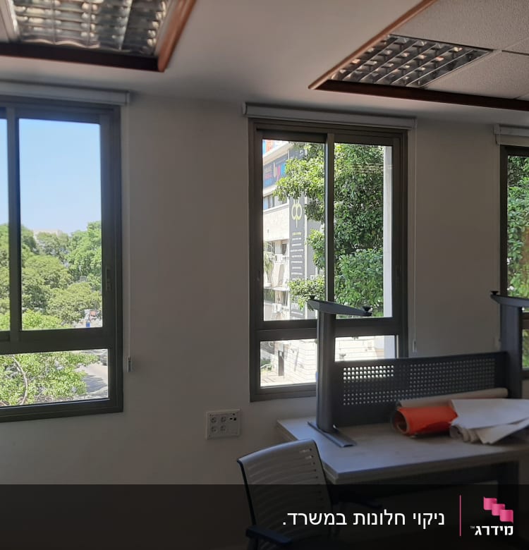 חדר עם שולחן הפוך, חלונות גדולים ועצים בחוץ